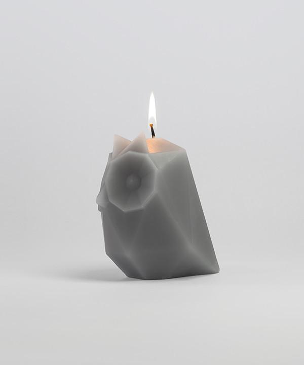 Side view of burning Ugla Owl shaped pyropet candle in grey.